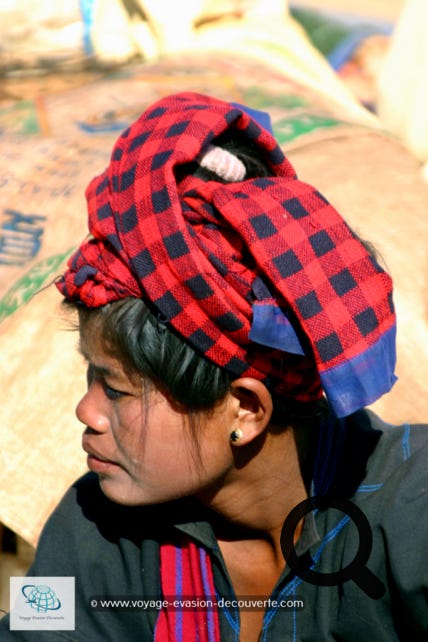 Des femmes portent leur coiffe rouge ou orange traditionnelle de Shan et souvent leur visage arborent un masque en Thanaka. C’est une pâte cosmétique blanc-jaune d’origine végétale couramment utilisée en Birmanie. Celle-ci s’étale sur les joues, le front, le nez et parfois les bras.