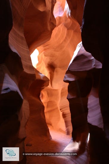 On dit que tout ce qui est petit est mignon, et bien ici, cela prend tout son sens… Ce petit canyon est tout simplement superbe, une vraie palette de couleurs ocres.  L’érosion et le vent ont creusé dans le grès cette crevasse étroite et très profonde, créant une draperie de roches qui  s’enroulent vers l’azur. Des vagues minérales qui s’entortillent d’ombre et de lumière. Un défilé creusé dans un plateau  de grès rouge et rose appelé Navajo sandstone. Des puits de lumière jouent sur les changements de couleurs des parois, illuminées quand le soleil est à son zénith.