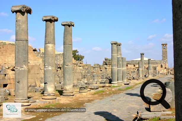 C’est une ancienne capitale de la région du Hauran. Située dans une région très fertile, au débouché des caravanes venant d’Arabie, Bosra connut la prospérité et joua un important rôle commercial. Très tôt christianisée, Bosra devint une étape importante sur l'ancienne route caravanière de La Mecque. Elle conserve, enserrés dans ses épaisses murailles, un théâtre romain du IIe siècle, des ruines paléochrétiennes et plusieurs mosquées plus tardives.