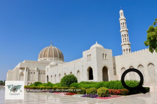 En approchant du site, la silhouette de la mosquée est apparue, majestueuse, avec son immense dôme doré et ses minarets élancés. Le contraste entre la blancheur éclatante de la pierre et le ciel bleu d'Oman donnait à l'ensemble un aspect presque irréel. L'entrée, parfaitement entretenue et silencieuse, invitait déjà au respect et à la contemplation.