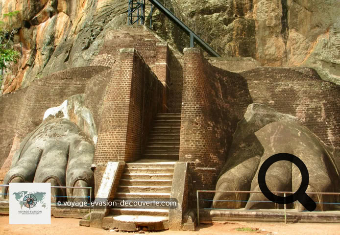 Vous arriverez à une terrasse connue sous le nom d'escalier du lion. De l'imposant lion, signe de  l'autorité royale, il ne reste que les pattes monumentales. C'est par cet escalier de fer zigzaguant à  flanc de rocher que l'on accède aux vestiges des palais, tout au sommet du rocher.  