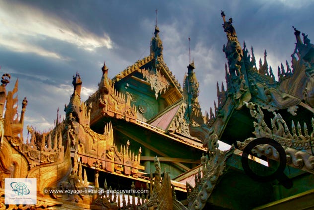 Situé à Mandalay, le monastère a été fondé en 1895 par des marchands chinois. Construit sur pilotis, il repose sur une imposante forêt de colonnes en rondins de teck. Sa toiture et sa devanture sont finement décorés de superbes sculptures en teck. Le hall principal a un toit de pagode à trois niveaux, le pavillon attenant est couronné d'une pagode à cinq niveaux avec un Hti.
