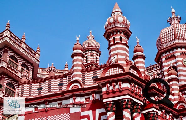 Construite en 1908, la mosquée est l'une des plus anciennes mosquées de Colombo et se situe dans le quartier de Pettah.  Le  bâtiment, de deux étages avec sa tour de l'horloge et ses minarets, le tout à rayures rouges et blanches est très original et très reconnaissable avec son style hybride. Il tire des éléments de l'architecture indigène indo-islamique et indienne, avec un mélange de renouveau gothique et de néo-classique. Une très belle réussite ! 