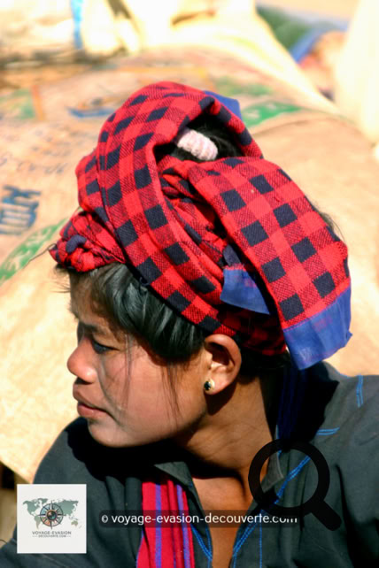 Des femmes portent leur coiffe rouge ou orange traditionnelle de Shan et souvent leur visage arborent un masque en Thanaka. C’est une pâte cosmétique blanc-jaune d’origine végétale couramment utilisée en Birmanie. Celle-ci s’étale sur les joues, le front, le nez et parfois les bras.