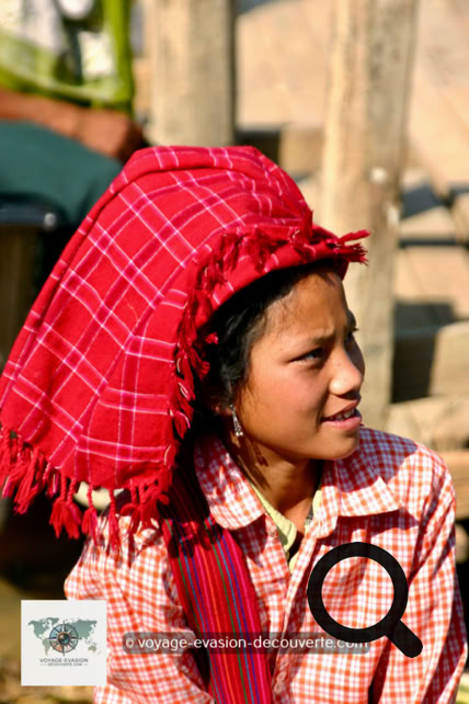 Des femmes portent leur coiffe rouge ou orange traditionnelle de Shan et souvent leur visage arborent un masque en Thanaka. C’est une pâte cosmétique blanc-jaune d’origine végétale couramment utilisée en Birmanie. Celle-ci s’étale sur les joues, le front, le nez et parfois les bras.