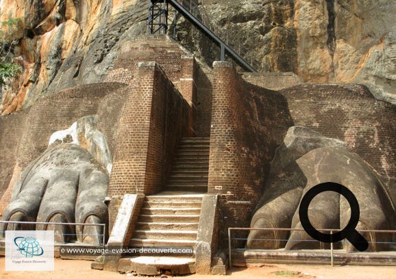 Vous arriverez à une terrasse connue sous le nom d'escalier du lion. De l'imposant lion, signe de  l'autorité royale, il ne reste que les pattes monumentales. C'est par cet escalier de fer zigzaguant à  flanc de rocher que l'on accède aux vestiges des palais, tout au sommet du rocher.  