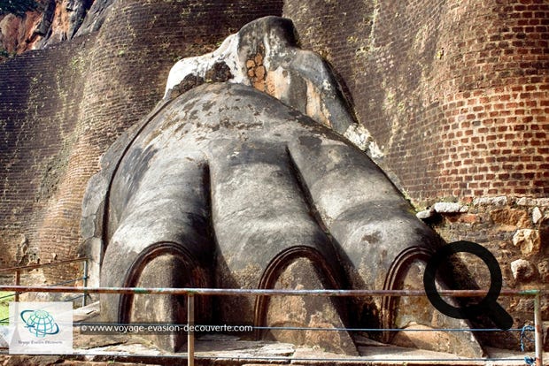 Vous arriverez à une terrasse connue sous le nom d'escalier du lion. De l'imposant lion, signe de  l'autorité royale, il ne reste que les pattes monumentales. C'est par cet escalier de fer zigzaguant à  flanc de rocher que l'on accède aux vestiges des palais, tout au sommet du rocher.  